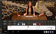 A smaller image of a female croupier wearing a sparkly gold dress hosting a game of baccarat for the Eurogrand live casino